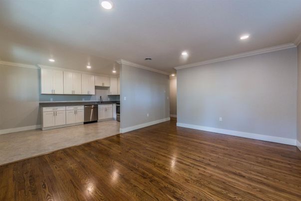 Empty room, Interior, Kitchen, Recessed Lighting, Stainless Steel Appliances, Wood Texture Flooring