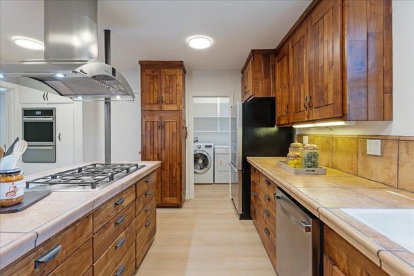 Interior, Kitchen, Recessed Lighting, Tile Countertops, Washer, Wood Texture Flooring
