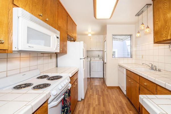 Interior, Kitchen, Pendant Lights, Tile Countertops, Washer, Wood Texture Flooring
