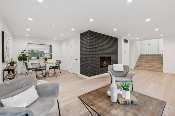 Dining room, Fireplace, Interior, Living room, Recessed Lighting, Stone Walls, Wood Texture Flooring