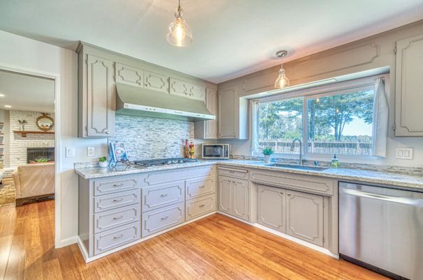 Fireplace, Interior, Kitchen, Pendant Lights, Recessed Lighting, Stainless Steel Appliances, Stone Walls, Wood Texture Flooring
