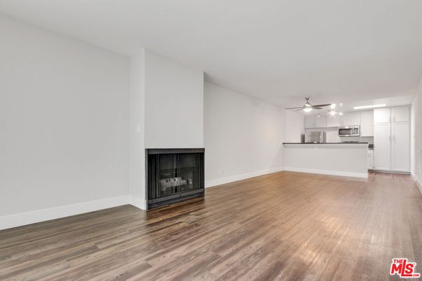 Empty room, Fireplace, Interior, Kitchen, Stainless Steel Appliances, Wood Texture Flooring