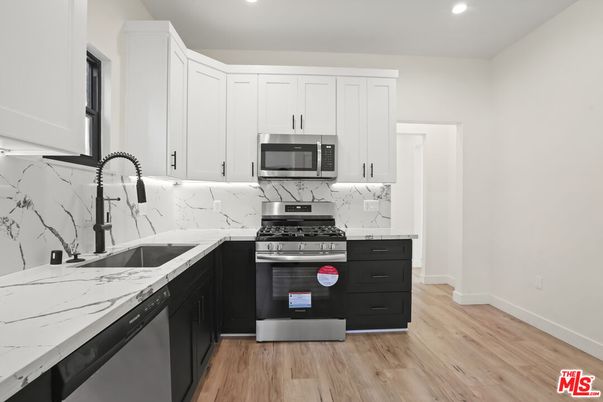 Interior, Kitchen, Marble Walls, Recessed Lighting, Stainless Steel Appliances, Wood Texture Flooring