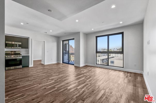 Empty room, Interior, Kitchen, Recessed Lighting, Stainless Steel Appliances, Wood Texture Flooring