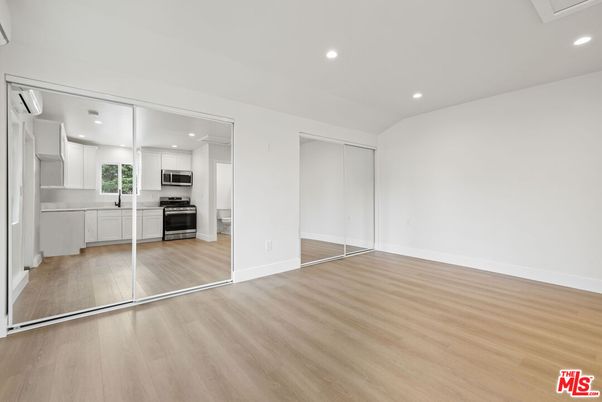 Empty room, Interior, Kitchen, Recessed Lighting, Stainless Steel Appliances, Wood Texture Flooring