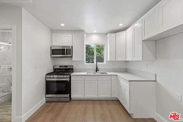 Interior, Kitchen, Marble Walls, Recessed Lighting, Stainless Steel Appliances, Wood Texture Flooring