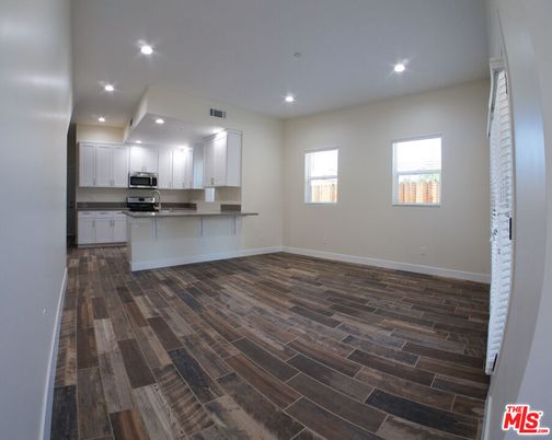 Empty room, Interior, Kitchen, Recessed Lighting, Stainless Steel Appliances, Wood Texture Flooring