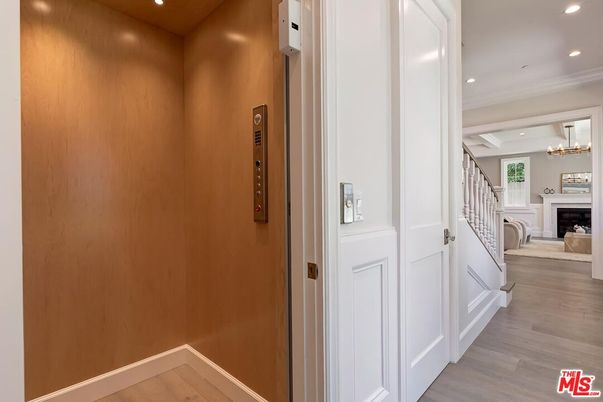 Chandelier, Elevator, Fireplace, Interior, Recessed Lighting, Wood Texture Flooring, Wooden Walls