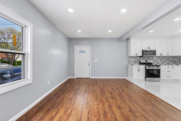 Empty room, Interior, Kitchen, Recessed Lighting, Stainless Steel Appliances, Wood Texture Flooring