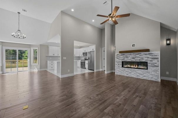Chandelier, Empty room, Fireplace, Interior, Kitchen, Pendant Lights, Recessed Lighting, Stainless Steel Appliances, Wood Texture Flooring