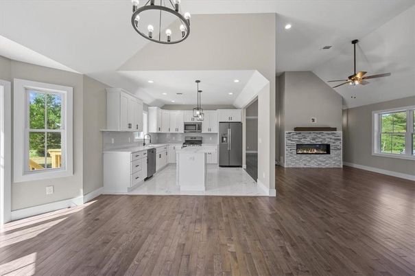 Empty room, Fireplace, Interior, Kitchen, Pendant Lights, Recessed Lighting, Stainless Steel Appliances, Wood Texture Flooring