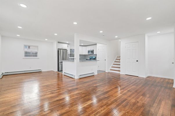 Empty room, Interior, Kitchen, Recessed Lighting, Stainless Steel Appliances, Wood Texture Flooring