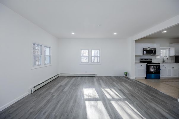 Empty room, Interior, Kitchen, Recessed Lighting, Stainless Steel Appliances, Wood Texture Flooring