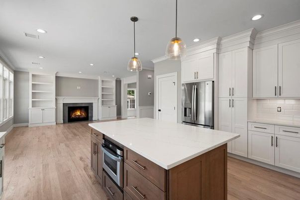 Empty room, Fireplace, Interior, Kitchen, Pendant Lights, Recessed Lighting, Stainless Steel Appliances, Wood Texture Flooring