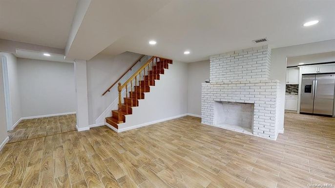 Empty room, Fireplace, Interior, Kitchen, Recessed Lighting, Stainless Steel Appliances, Stone Walls, Wood Texture Flooring