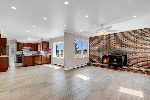 Empty room, Fireplace, Interior, Kitchen, Recessed Lighting, Stainless Steel Appliances, Stone Walls, Wood Texture Flooring