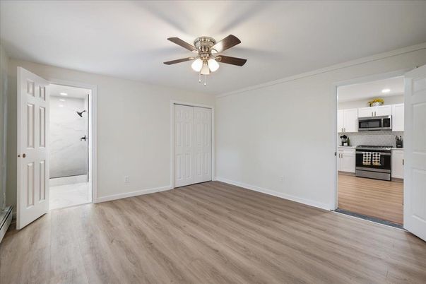 Empty room, Interior, Kitchen, Recessed Lighting, Stainless Steel Appliances, Wood Texture Flooring