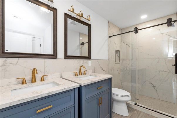 Bathroom, Dual Sink Vanities, Glass Shower, Interior, Marble Walls, Recessed Lighting, Wood Texture Flooring