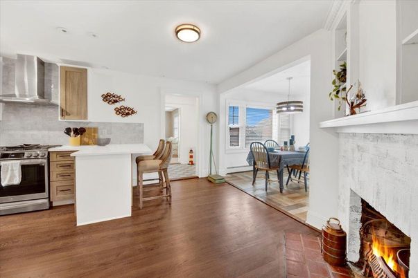 Dining room, Fireplace, Interior, Kitchen, Pendant Lights, Stainless Steel Appliances, Wood Texture Flooring