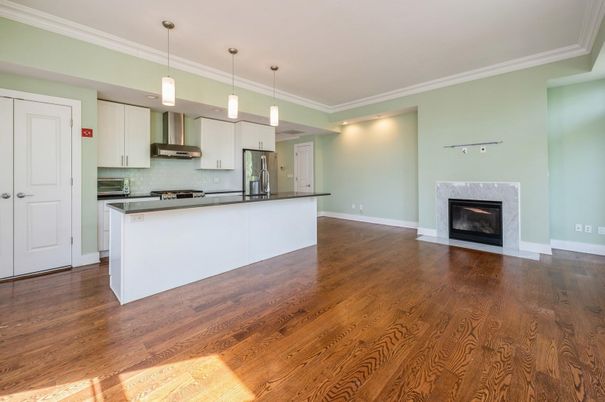 Empty room, Fireplace, Interior, Kitchen, Pendant Lights, Recessed Lighting, Stainless Steel Appliances, Wood Texture Flooring