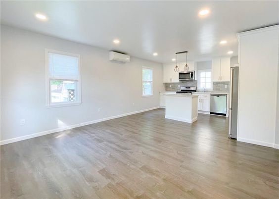 Empty room, Interior, Kitchen, Pendant Lights, Recessed Lighting, Stainless Steel Appliances, Wood Texture Flooring