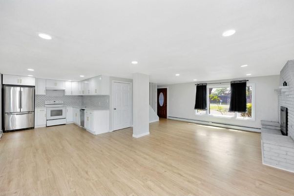Empty room, Fireplace, Interior, Kitchen, Recessed Lighting, Stainless Steel Appliances, Wood Texture Flooring
