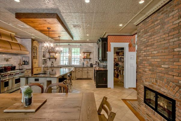 Chandelier, Dining room, Fireplace, Interior, Kitchen, Pendant Lights, Recessed Lighting, Stainless Steel Appliances, Stone Walls, Wooden Ceilings