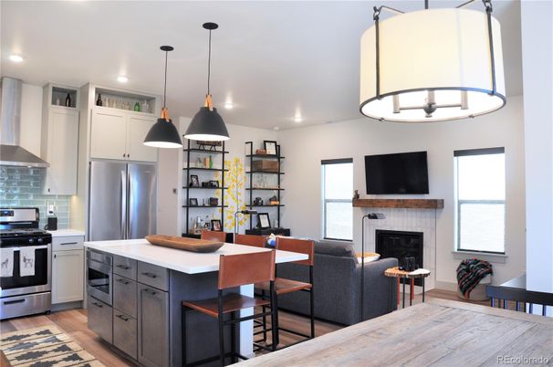 Fireplace, Interior, Kitchen, Living room, Pendant Lights, Recessed Lighting, Stainless Steel Appliances, Wood Texture Flooring