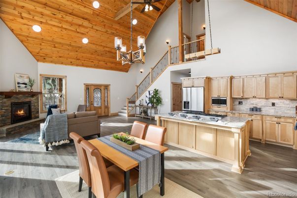 Chandelier, Dining room, Fireplace, Interior, Kitchen, Living room, Pendant Lights, Recessed Lighting, Stainless Steel Appliances, Wooden Beams, Wooden Ceilings, Wood Texture Flooring