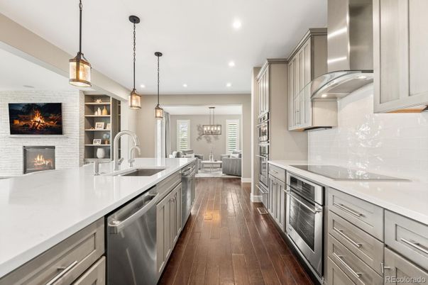 Chandelier, Fireplace, Interior, Kitchen, Pendant Lights, Recessed Lighting, Stainless Steel Appliances, Stone Walls, Wood Texture Flooring