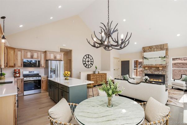 Chandelier, Fireplace, Interior, Kitchen, Living room, Pendant Lights, Recessed Lighting, Stainless Steel Appliances, Wood Texture Flooring