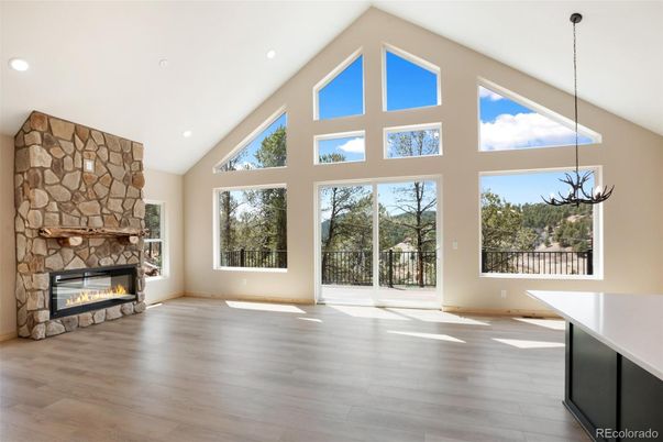 Chandelier, Empty room, Fireplace, Interior, Recessed Lighting, Stone Walls, Wood Texture Flooring