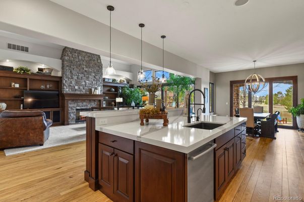 Chandelier, Dining room, Fireplace, Interior, Kitchen, Living room, Pendant Lights, Stainless Steel Appliances, Stone Walls, Wood Texture Flooring