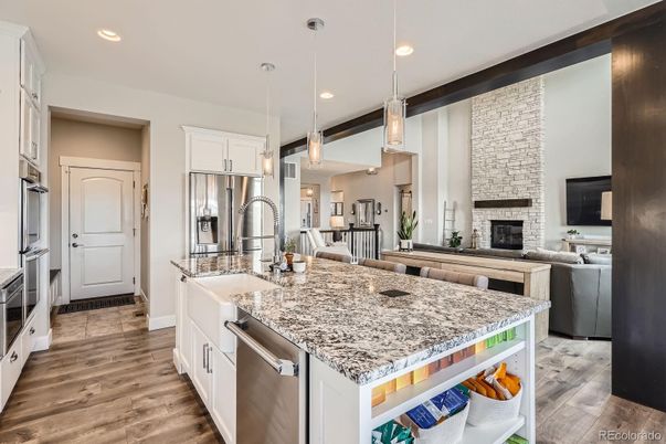 Fireplace, Interior, Kitchen, Pendant Lights, Recessed Lighting, Stainless Steel Appliances, Stone Walls, Wood Texture Flooring