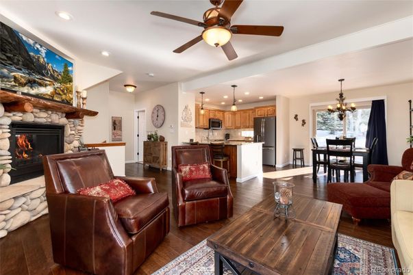 Chandelier, Dining room, Fireplace, Interior, Kitchen, Living room, Pendant Lights, Recessed Lighting, Stainless Steel Appliances, Stone Walls, Wood Texture Flooring