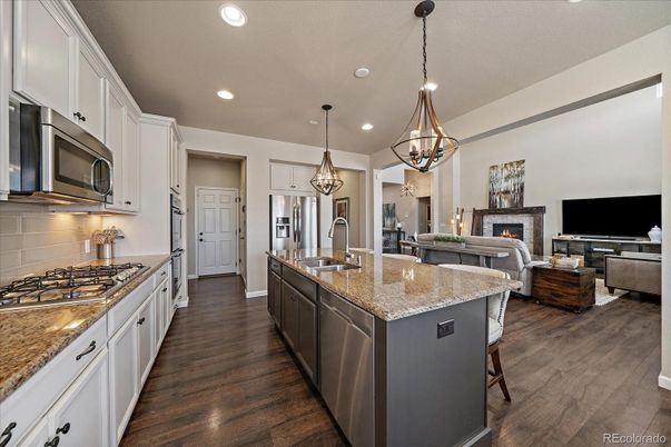 Chandelier, Fireplace, Interior, Kitchen, Living room, Pendant Lights, Recessed Lighting, Stainless Steel Appliances, Wood Texture Flooring
