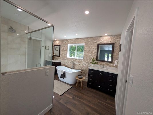 Bathroom, Dual Sink Vanities, Free Standing Baths, Glass Shower, Interior, Recessed Lighting, Stone Walls, Wood Texture Flooring