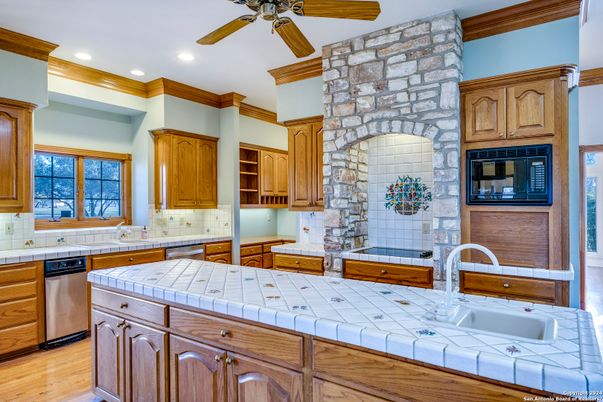 Fireplace, Interior, Kitchen, Recessed Lighting, Stone Walls, Tile Countertops, Wood Texture Flooring