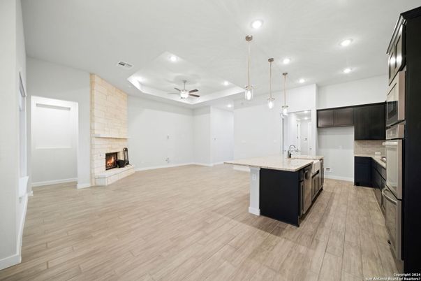 Empty room, Fireplace, Interior, Kitchen, Pendant Lights, Recessed Lighting, Stone Walls, Wood Texture Flooring