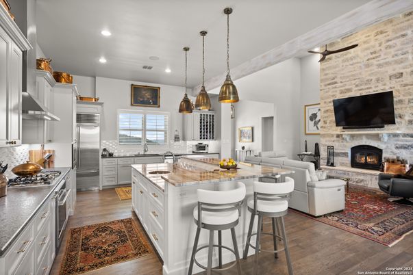Fireplace, Interior, Kitchen, Living room, Pendant Lights, Recessed Lighting, Stainless Steel Appliances, Stone Walls, Wood Texture Flooring