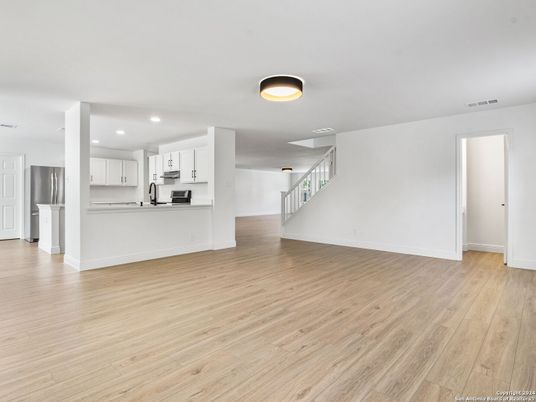 Empty room, Interior, Kitchen, Recessed Lighting, Stainless Steel Appliances, Wood Texture Flooring