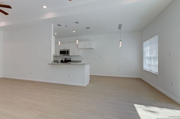 Empty room, Interior, Kitchen, Pendant Lights, Recessed Lighting, Stainless Steel Appliances, Wood Texture Flooring