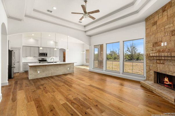 Fireplace, Interior, Kitchen, Pendant Lights, Recessed Lighting, Stainless Steel Appliances, Stone Walls, Wood Texture Flooring