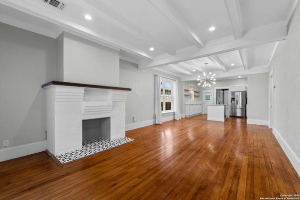 Empty room, Fireplace, Interior, Kitchen, Pendant Lights, Recessed Lighting, Stainless Steel Appliances, Wood Texture Flooring