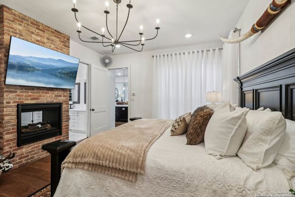 Bedroom, Chandelier, Fireplace, Interior, Recessed Lighting, Stone Walls, Wood Texture Flooring