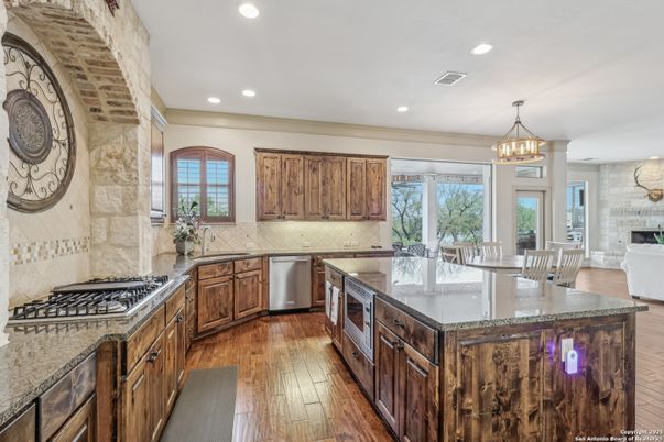 Chandelier, Dining room, Interior, Kitchen, Pendant Lights, Recessed Lighting, Stainless Steel Appliances, Stone Walls, Wood Texture Flooring