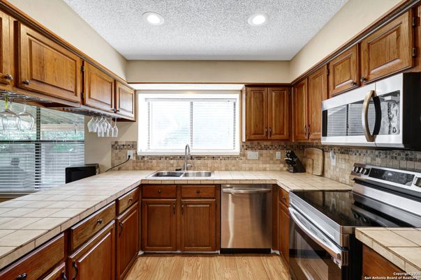 Interior, Kitchen, Recessed Lighting, Stainless Steel Appliances, Tile Countertops, Wood Texture Flooring