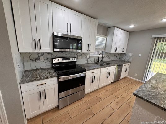 Interior, Kitchen, Marble Walls, Recessed Lighting, Stainless Steel Appliances, Wood Texture Flooring