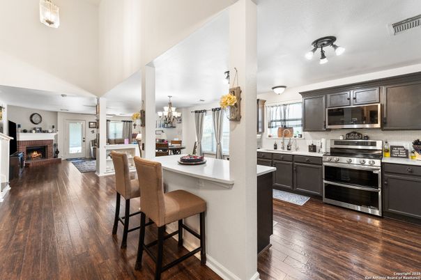 Chandelier, Dining room, Fireplace, Interior, Kitchen, Stainless Steel Appliances, Wood Texture Flooring