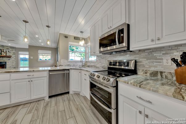 Fireplace, Interior, Kitchen, Pendant Lights, Stainless Steel Appliances, Stone Walls